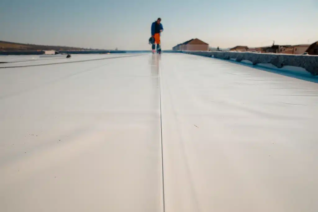 Roofer repairing a flat roof in Albuquerque.